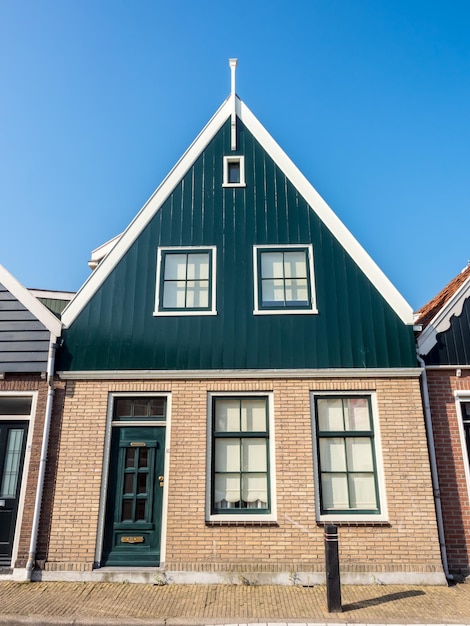 Edifícios abrigam arquitetura na pequena cidade de pescadores de Volendam da Holanda sob céu nevoento branco