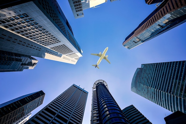 Edifícios altos da cidade e um avião voando em cima