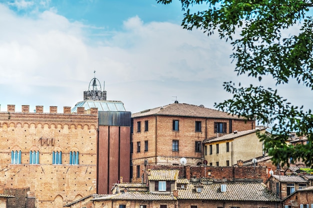 Edificios antiguos en Siena bajo un cielo azul con nubes Italia