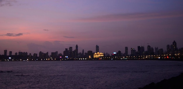 Edificios de la ciudad iluminados contra el cielo al atardecer