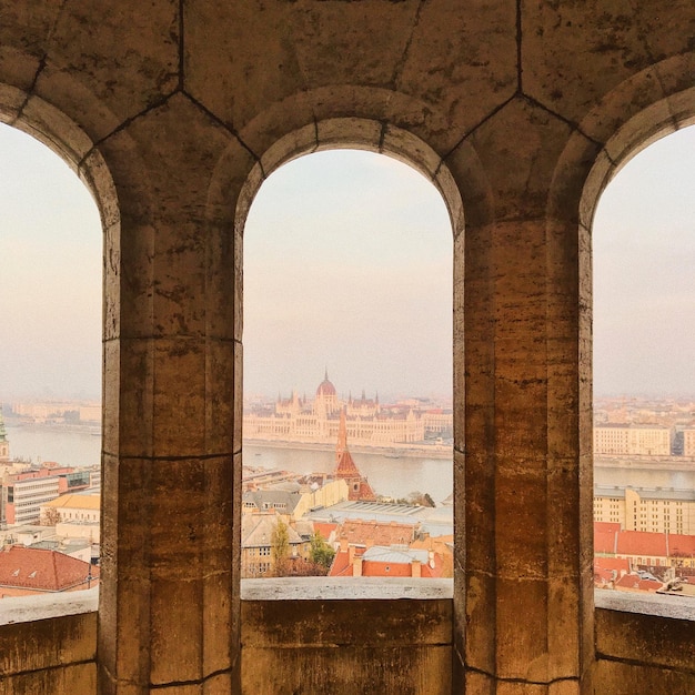 Edificios de la ciudad vistos a través de una ventana de arco