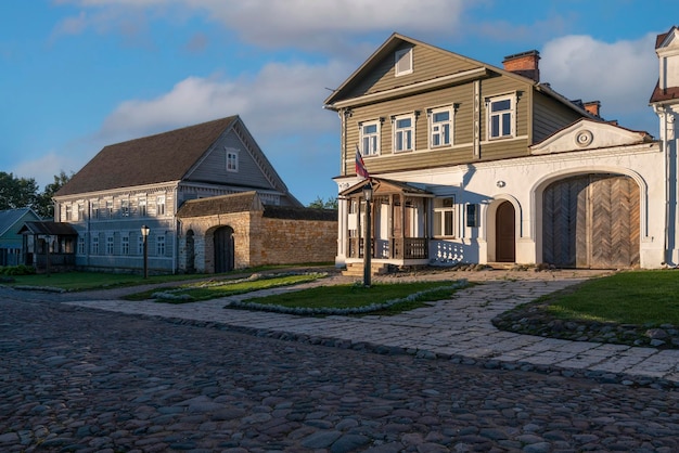 Edificios comerciales de fincas en la calle Pechorskaya en un día de verano Izborsk Pskov región Rusia