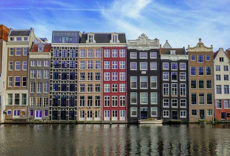 Edifícios de arquitetura em Damrak durante o pôr do sol em Amsterdã