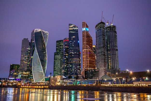 Edifícios de arranha-céus do centro de negócios internacional da cidade de Moscou com visão noturna panorâmica de janelas.