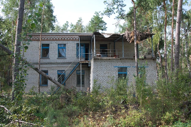 Edifícios de tijolos destruídos no território de um antigo acampamento infantil na floresta de verão Ulyanovsk
