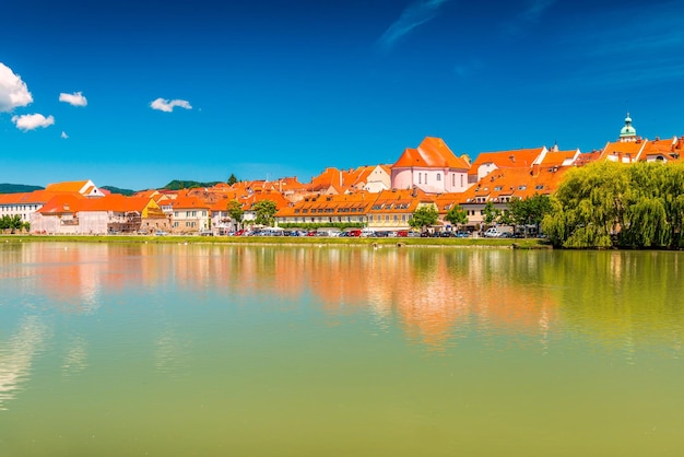 Edificios históricos de Maribor reflejados en el agua del río Drava, Eslovenia