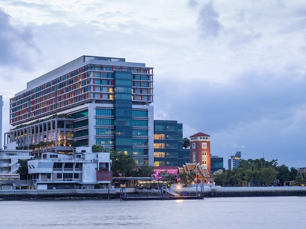 Edificios del hospital Siriraj a lo largo del río Chao Phraya en Bangkok bajo el cielo nublado del crepúsculo al atardecer en Tailandia