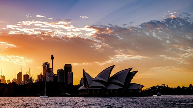 Foto edificios icónicos de mundos ópera de sídney con puesta de sol