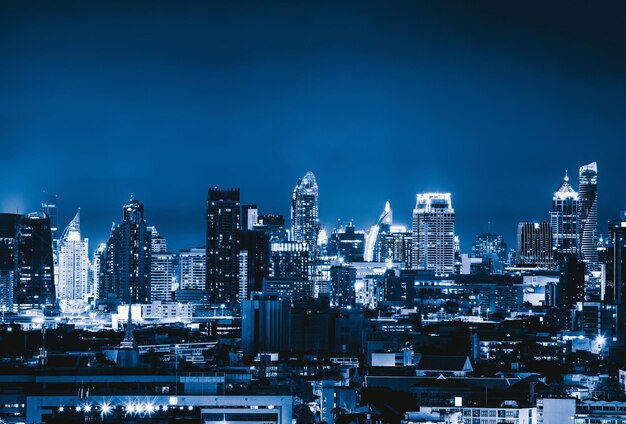 Edificios iluminados en la ciudad contra el cielo azul