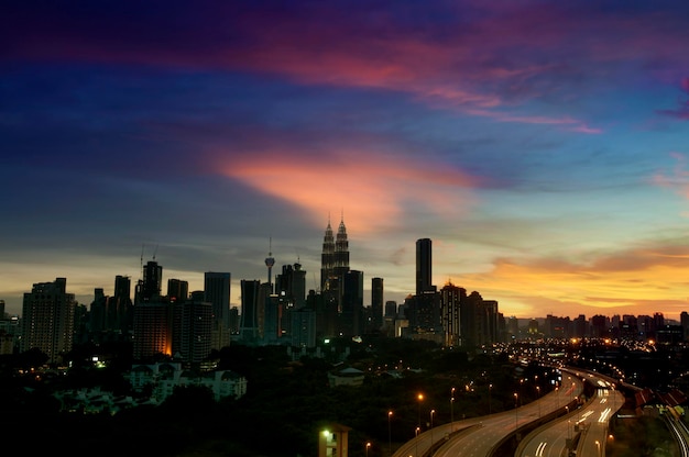 Edificios iluminados en la ciudad contra el cielo durante la puesta de sol