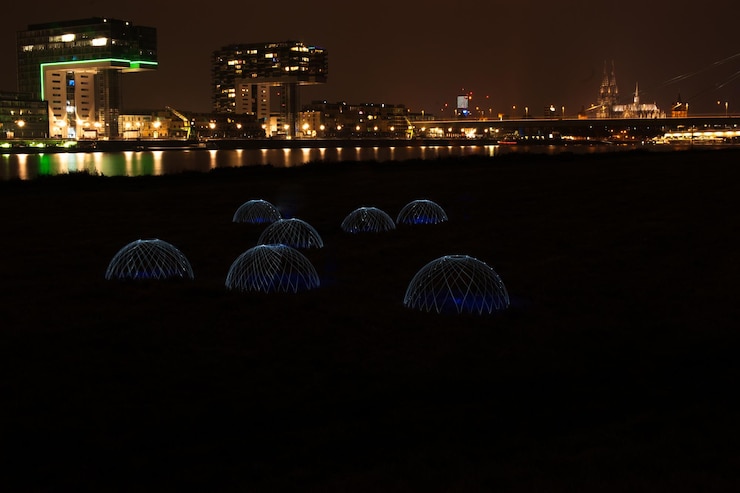 Foto edificios iluminados en la distancia con césped en primer plano
