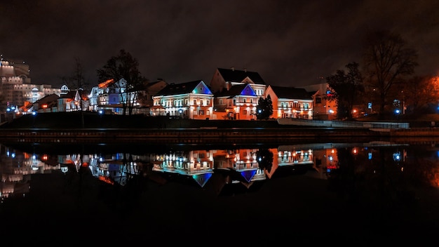 Foto edificios iluminados por el lago contra el cielo nocturno
