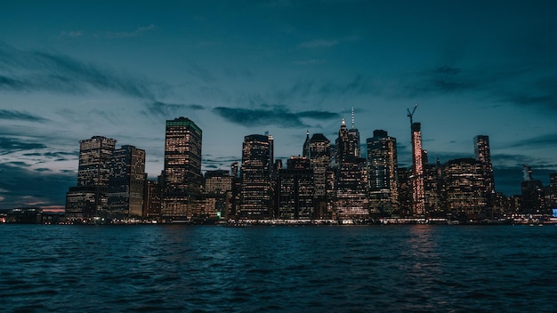 Edifícios iluminados pelo mar contra o céu ao anoitecer