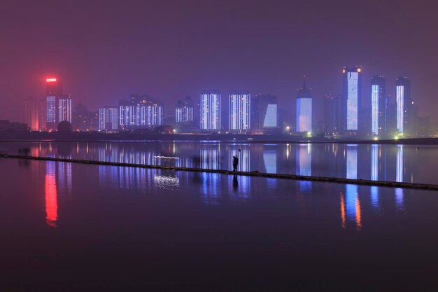 Edifícios iluminados pelo rio contra o céu à noite