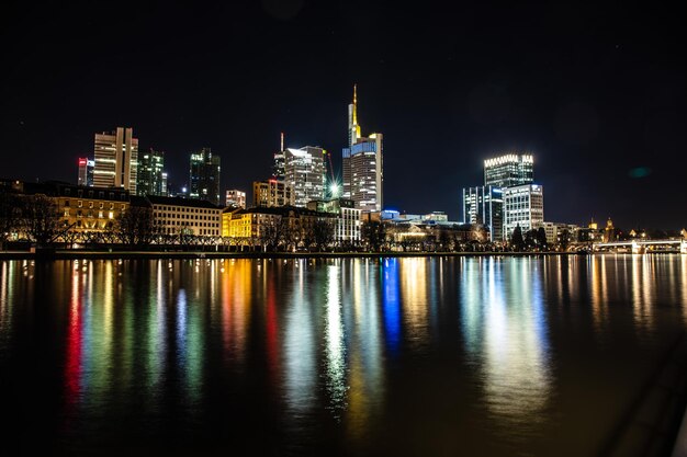 Edificios iluminados por el río contra el cielo por la noche