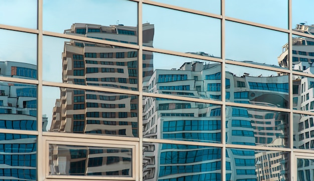 Edifícios modernos curvados refletidos nas janelas espelhadas