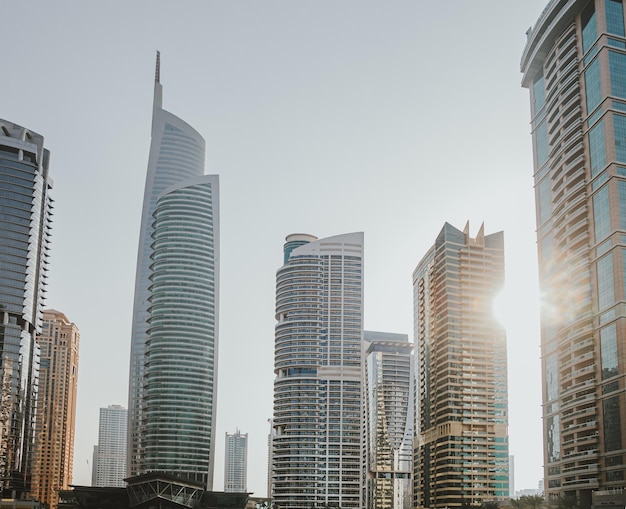 Edifícios modernos de arranha-céus da cidade ao pôr do sol com torres comerciais e residenciais ao redor de um lago