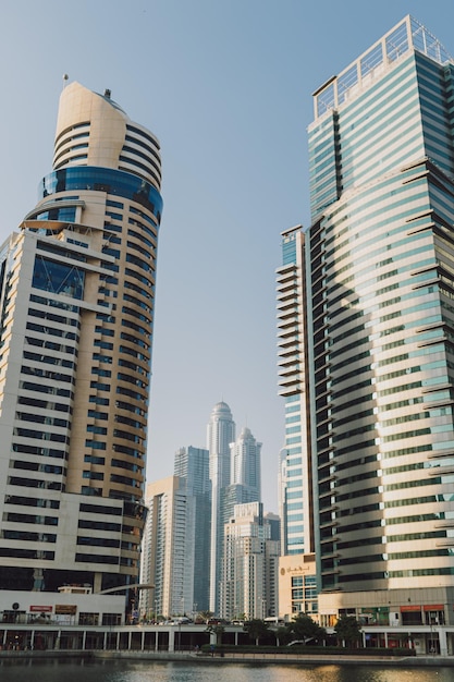 Edifícios modernos de arranha-céus da cidade ao pôr do sol com torres comerciais e residenciais ao redor de um lago