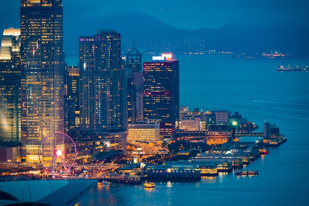 Edifícios modernos iluminados pelo mar contra o céu à noite