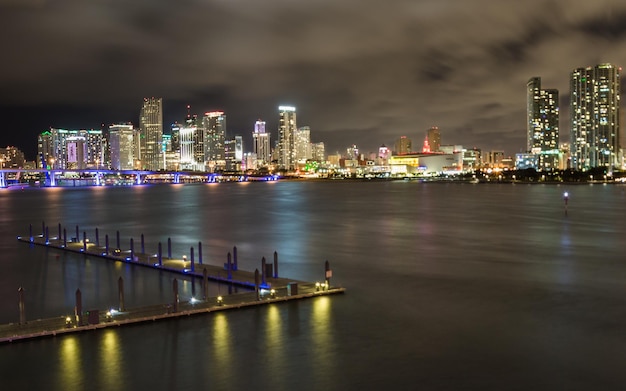 Edifícios modernos iluminados pelo rio contra o céu à noite