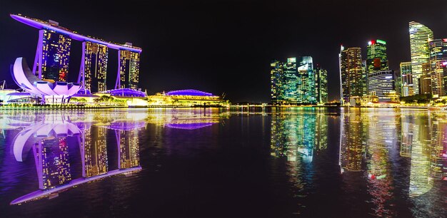 Foto edificios modernos iluminados por el río contra el cielo nocturno