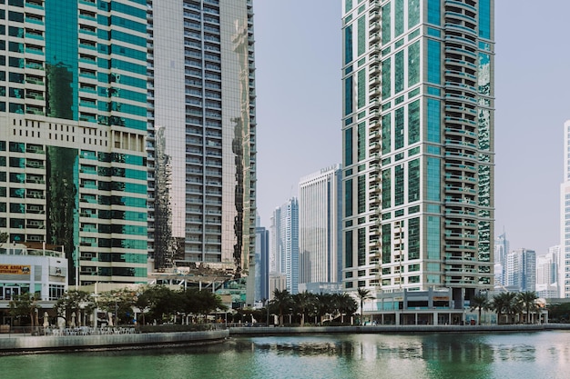 Edificios modernos de rascacielos de la ciudad al atardecer con torres comerciales y residenciales alrededor de un lago