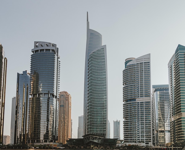 Edificios modernos de rascacielos de la ciudad al atardecer con torres comerciales y residenciales alrededor de un lago