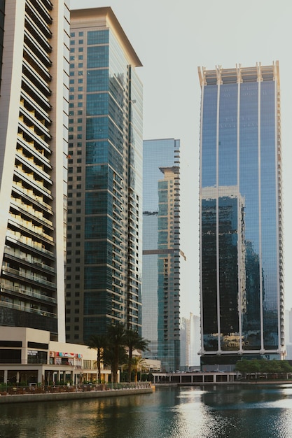 Edificios modernos de rascacielos de la ciudad al atardecer con torres comerciales y residenciales alrededor de un lago