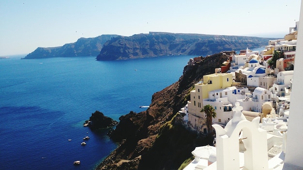 Edifícios na montanha junto ao mar em Santorini contra o céu