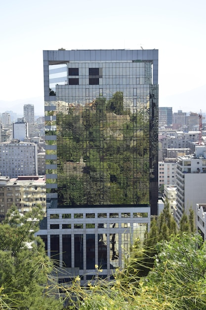 Los edificios se reflejan en la fachada espejada de un moderno rascacielos Santiago Chile