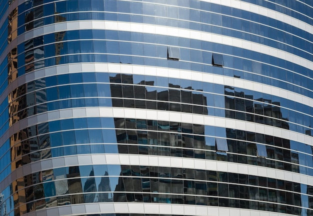 Los edificios se reflejan en las ventanas del edificio de oficinas moderno