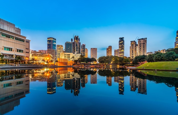 Edifícios refletindo sobre o lago calmo na cidade ao anoitecer