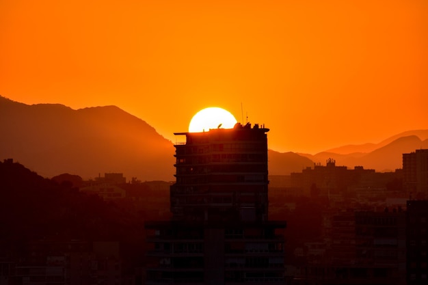 Foto edificios en silueta contra el cielo naranja