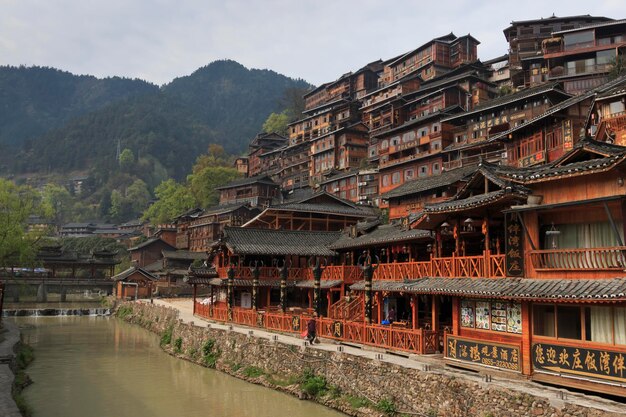 Edificios tradicionales por el río contra la montaña