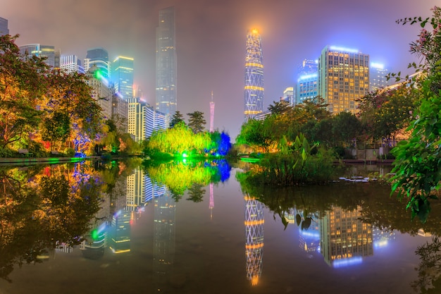 Edificios urbanos modernos de la opinión y de la costa de la noche en el parque en Guangzhou, China