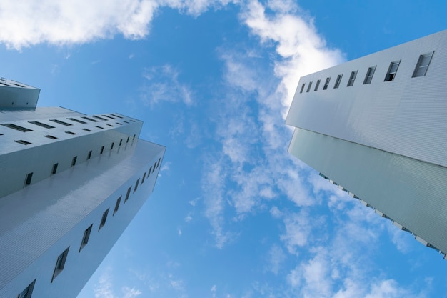 Edificios vistos desde abajo, con cielo azul y nubes.