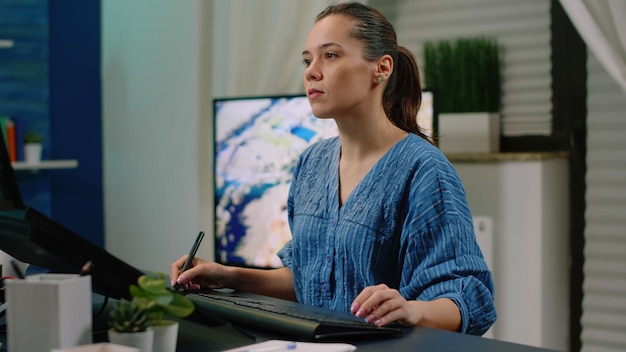 Editor de fotografía haciendo trabajos de retoque con monitor de pantalla táctil y tableta gráfica en el estudio. Mujer fotógrafa trabajando en la edición de imágenes con software de retoque. Diseñador grafico