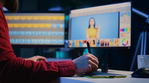 Editor de fotos experto navegando por las imágenes de la sesión de fotos para encontrar y corregir puntos defectuosos utilizando una tableta gráfica de primer plano Fotógrafo editando imágenes con un lápiz en el dispositivo de pantalla táctil