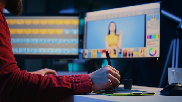 Foto editor de fotos experto navegando por las imágenes de la sesión de fotos para encontrar y corregir puntos defectuosos utilizando una tableta gráfica de primer plano fotógrafo editando imágenes con un lápiz en el dispositivo de pantalla táctil
