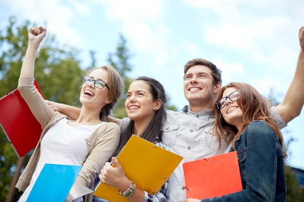 educação, amizade, sucesso e conceito adolescente - grupo de estudantes felizes mostrando gesto de triunfo no campus ou parque