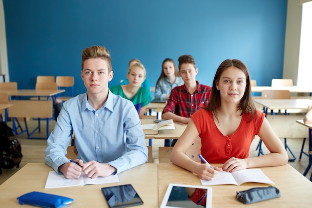 educação, aprendizagem e conceito de pessoas - grupo de alunos com notebooks e computadores tablet pc na aula escolar