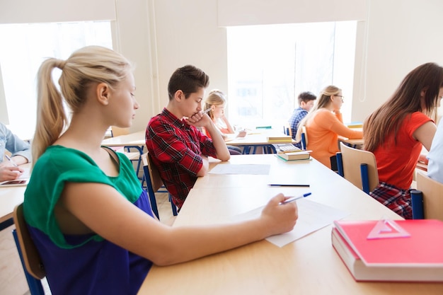 Foto educação, aprendizagem e conceito de pessoas - grupo de alunos escrevendo teste escolar