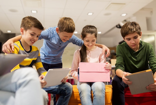 educação, crianças, tecnologia e conceito de pessoas - grupo de crianças felizes com computadores tablet pc aprendendo na escola