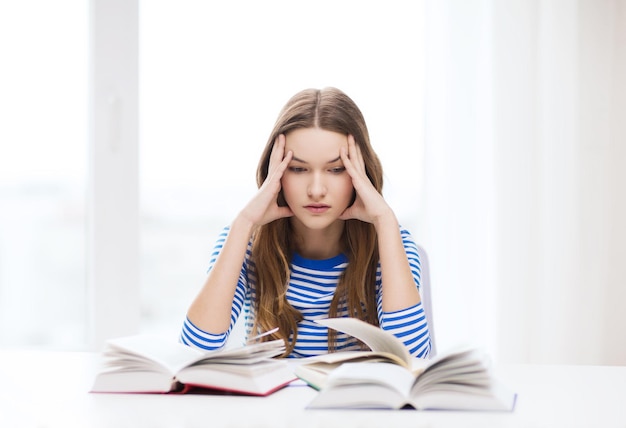 educação e conceito de casa - estudante estressada com livros