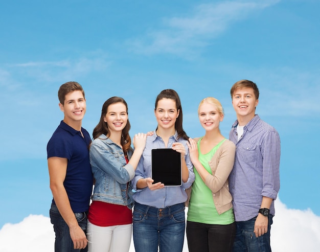 educação e conceito de tecnologia moderna - estudantes sorridentes mostrando a tela do computador tablet pc em branco sobre o fundo do céu azul