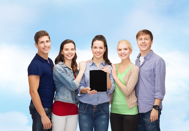 educação e conceito de tecnologia moderna - estudantes sorridentes mostrando a tela do computador tablet pc em branco sobre o fundo do céu azul
