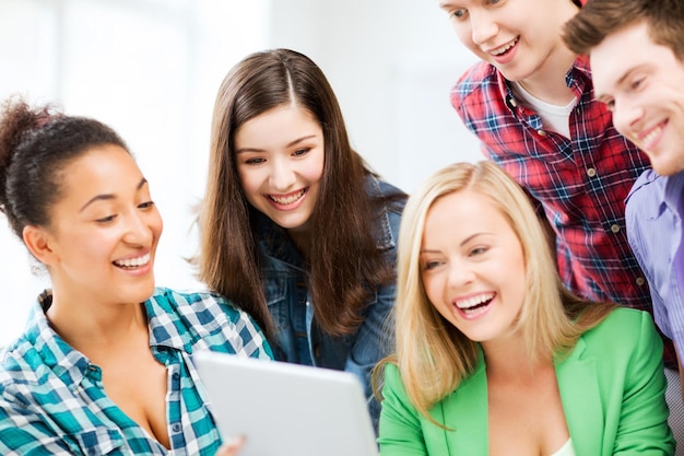 Educação e internet - alunos sorridentes olhando para o tablet pc em palestra na escola