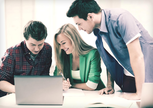 Educação e internet - estudantes sorridentes escrevendo teste ou exame em palestra na escola