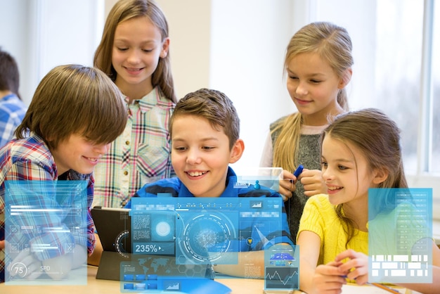 educação, ensino fundamental, aprendizagem, tecnologia e conceito de pessoas - grupo de crianças com computador tablet pc se divertindo no intervalo na sala de aula sobre projeções de telas virtuais