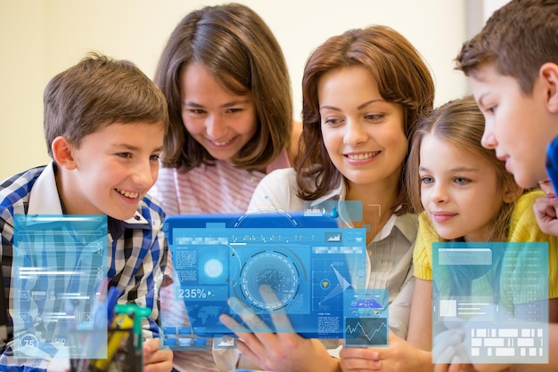 Foto educação, ensino fundamental, aprendizagem, tecnologia e conceito de pessoas - grupo de crianças com professor olhando para computador tablet pc em sala de aula sobre projeções de telas virtuais